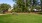 a large grassy area with trees in the background