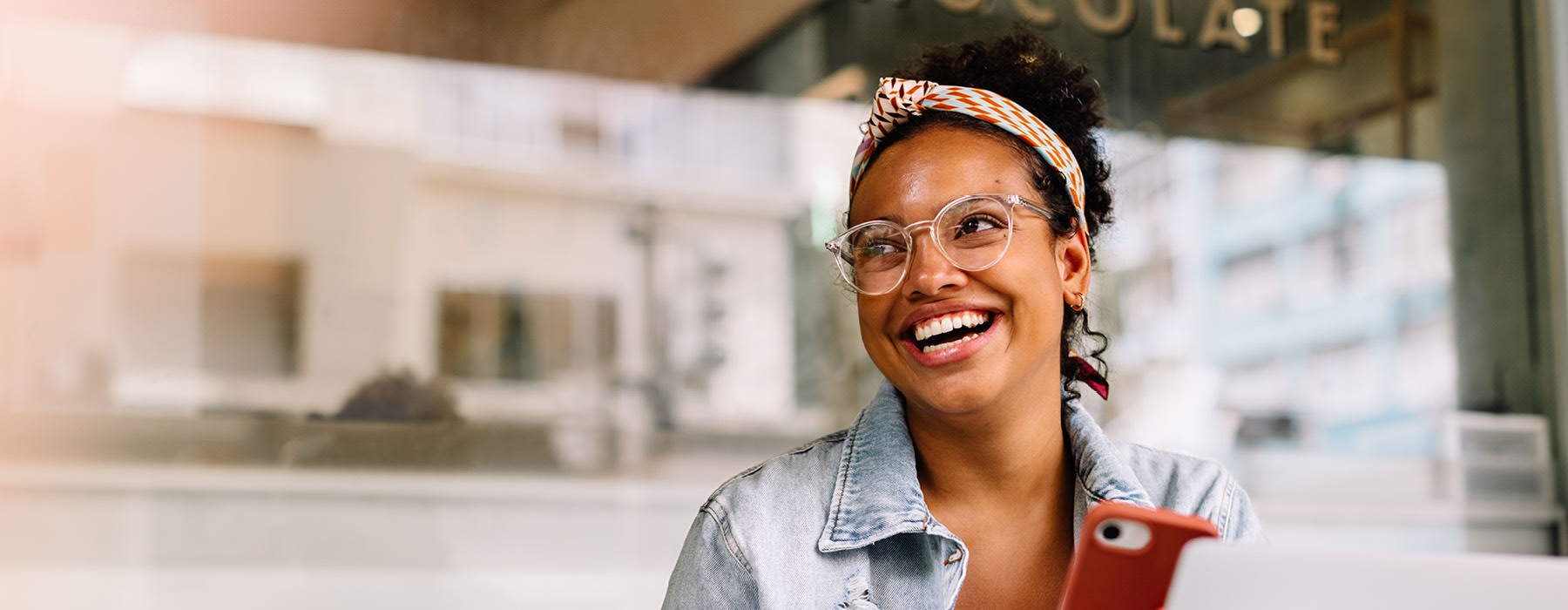 a person smiling while holding a red phone