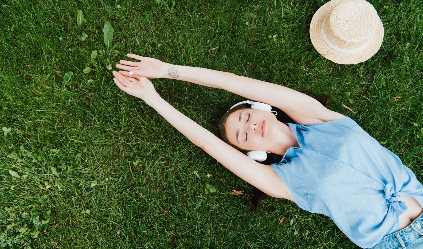 Woman enjoying a park day and listening to music via headphones