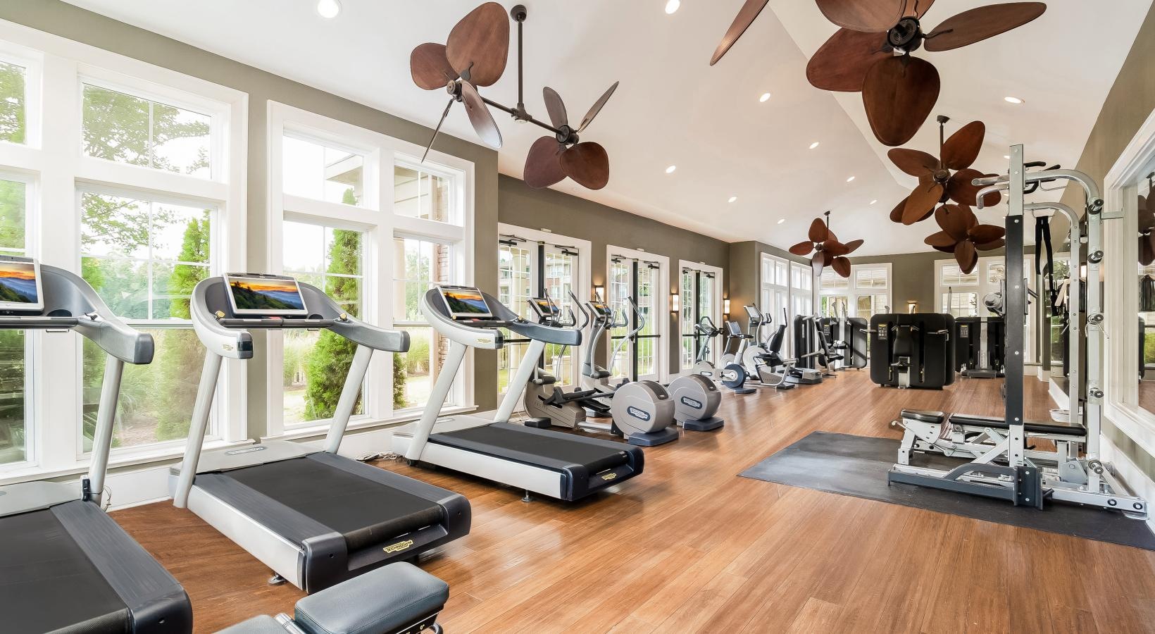 Quick access to state-of-the-art amenities a room with exercise equipment and a large window